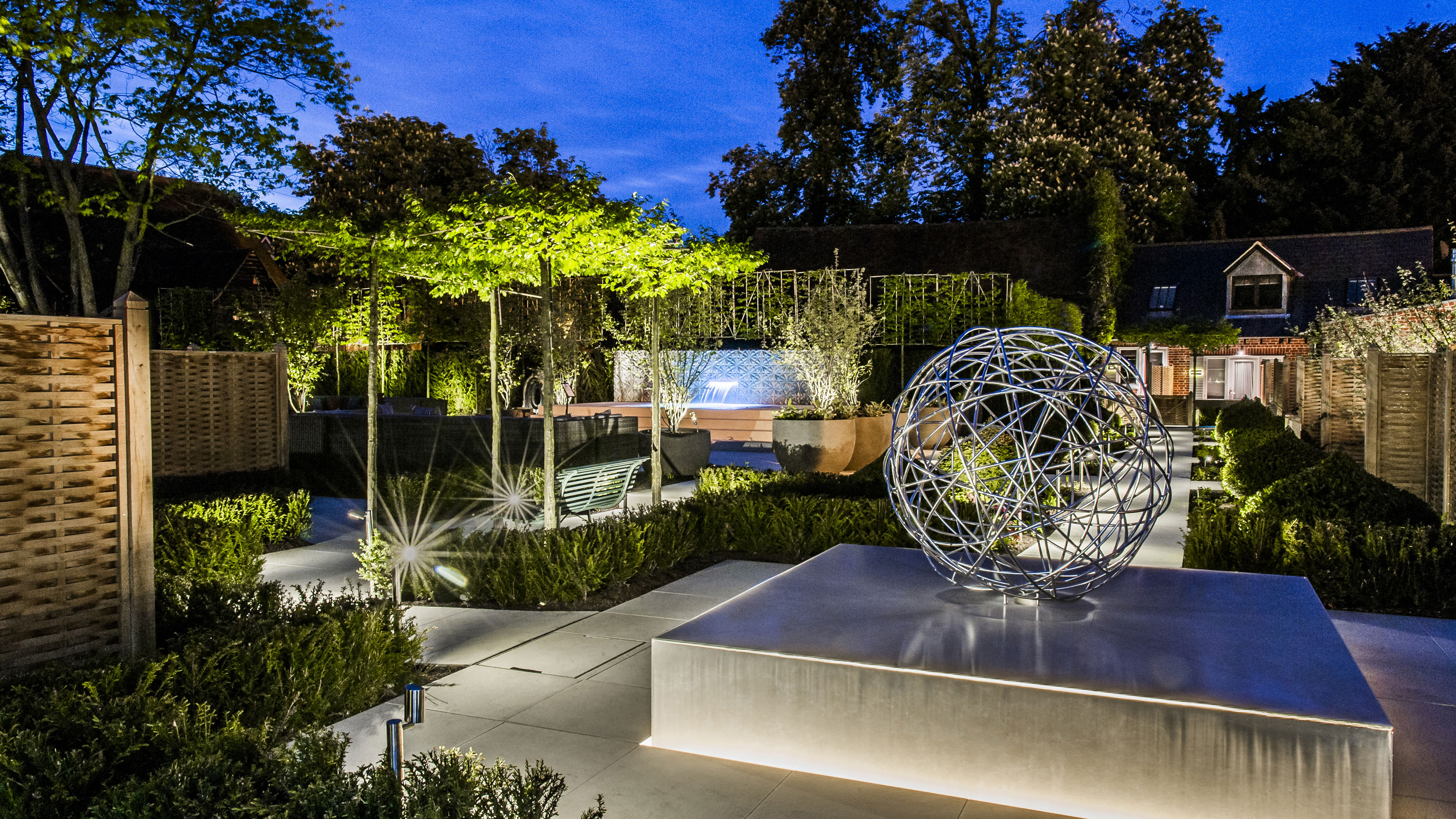 outdoor tree lighting ideas: modern urban garden with lit trees