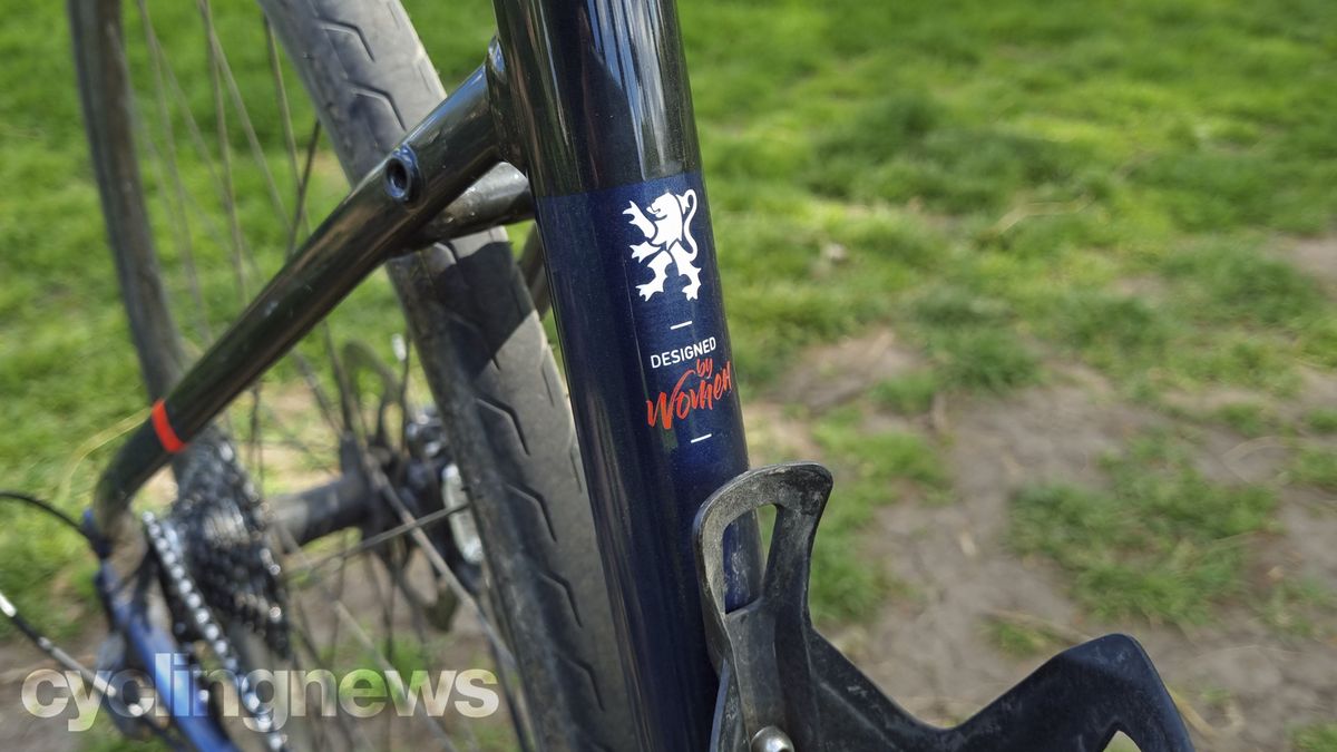 A close up of the Triban's seat tube with a white and red painted logo that says 'designed by women'