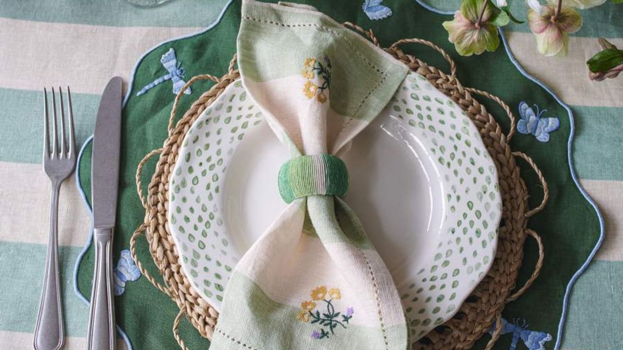 An embroidered napkin on a white plate.