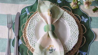 An embroidered napkin on a white plate.
