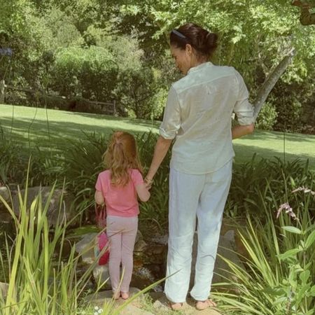 Meghan Markle holding hands with Princess Lilibet outside