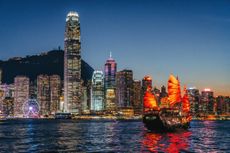 Hong Kong stocks: view of a boat in Hong Kong harbour at twilight