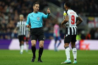 Referee, Danny Makkelie of Netherlands in discussion with Callum Wilson of Newcastle United during the UEFA Champions League match between Newcastle United FC and AC Milan at St. James Park on December 13, 2023 in Newcastle upon Tyne, England