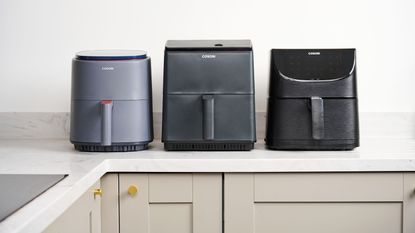 Three Cosori air fryers lined up on the kitchen counter