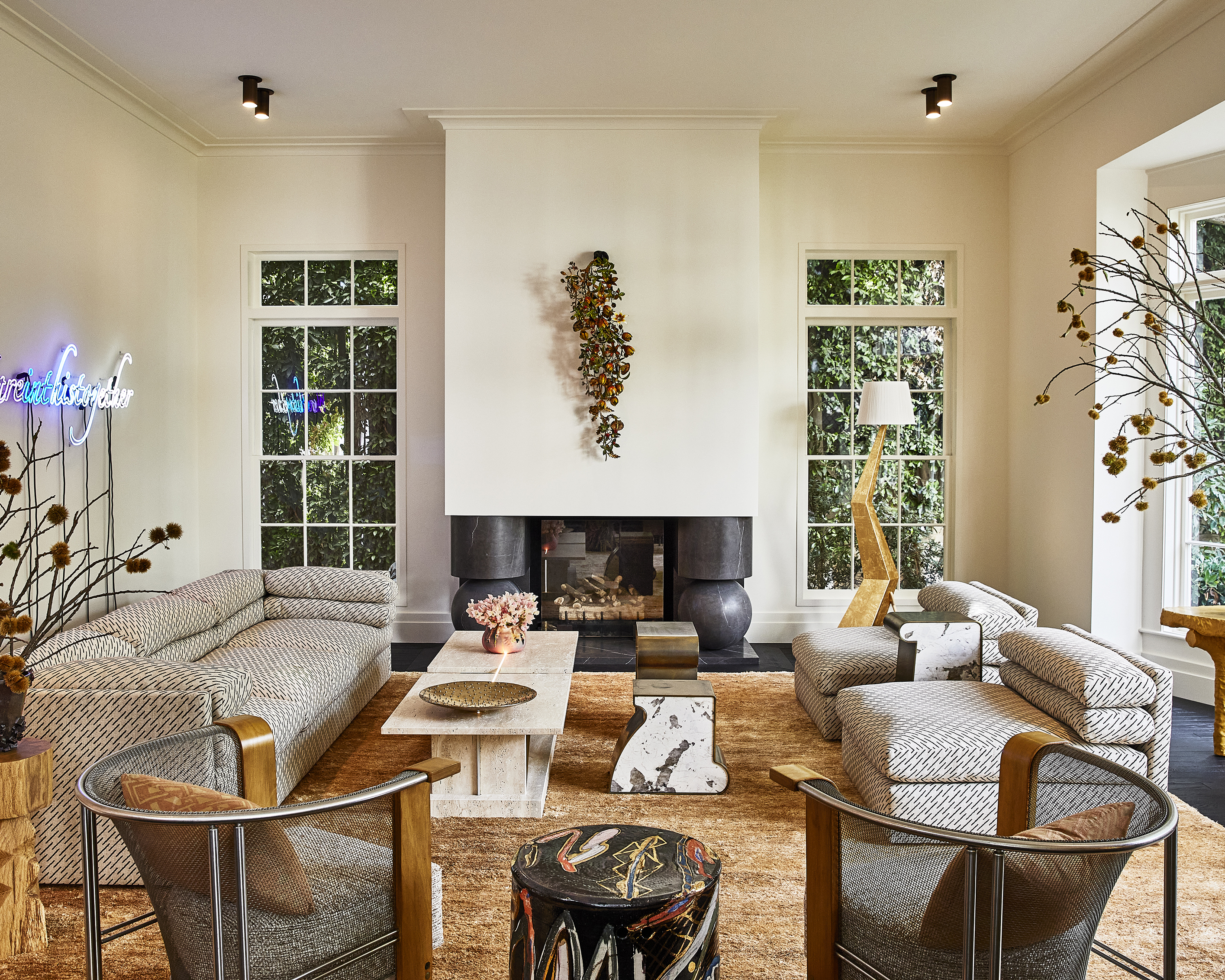 large off-white living room with symetrical layout of furniture and modern seating on a large rust colored rug