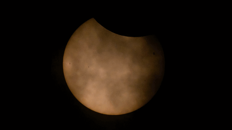 The ISS is silhouetted on the sun's face during a partial eclipse in this gif.