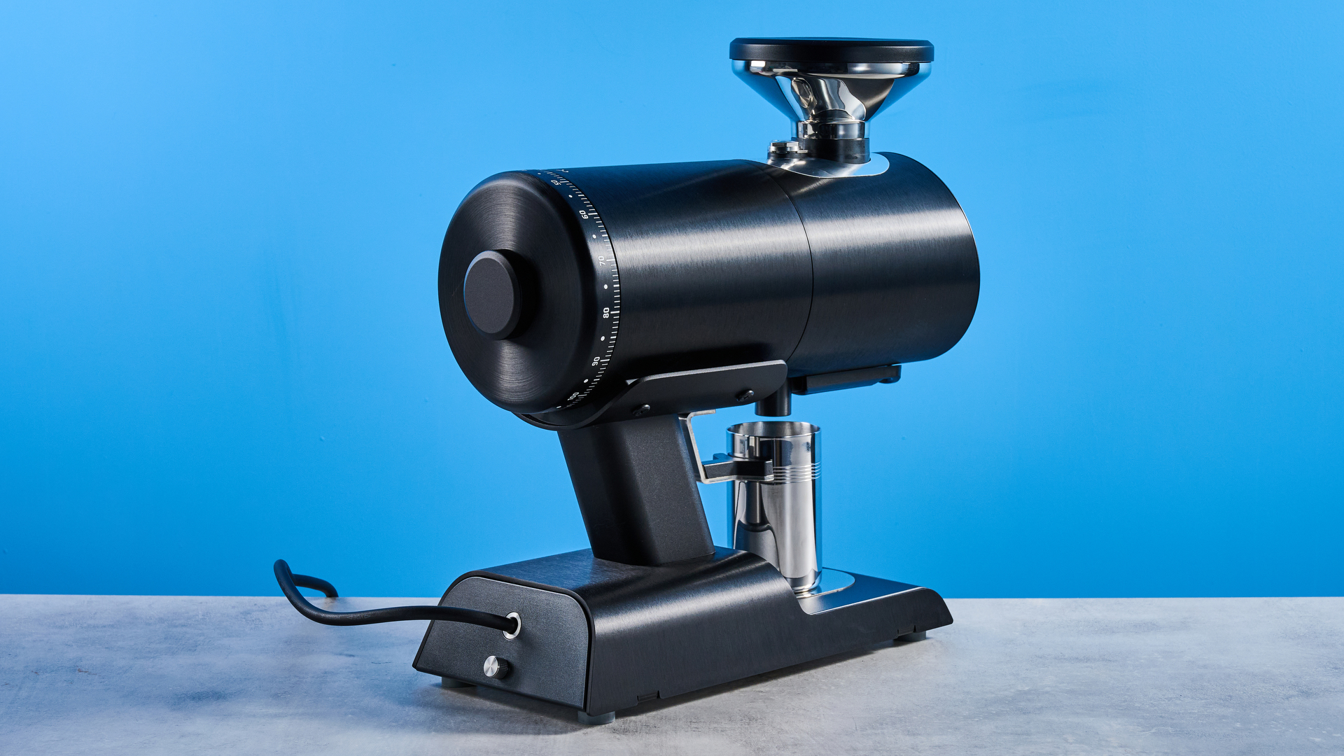 the mazzer philos coffee grinder in black and stainless steel photographed against a tom's guide blue background