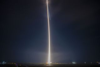 Vulcan Centaur rocket launch streak of light through a dark sky.