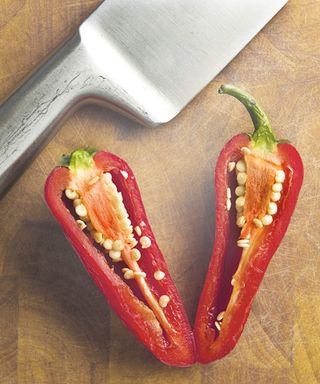 Sliced red chili pepper on wooden chopping board