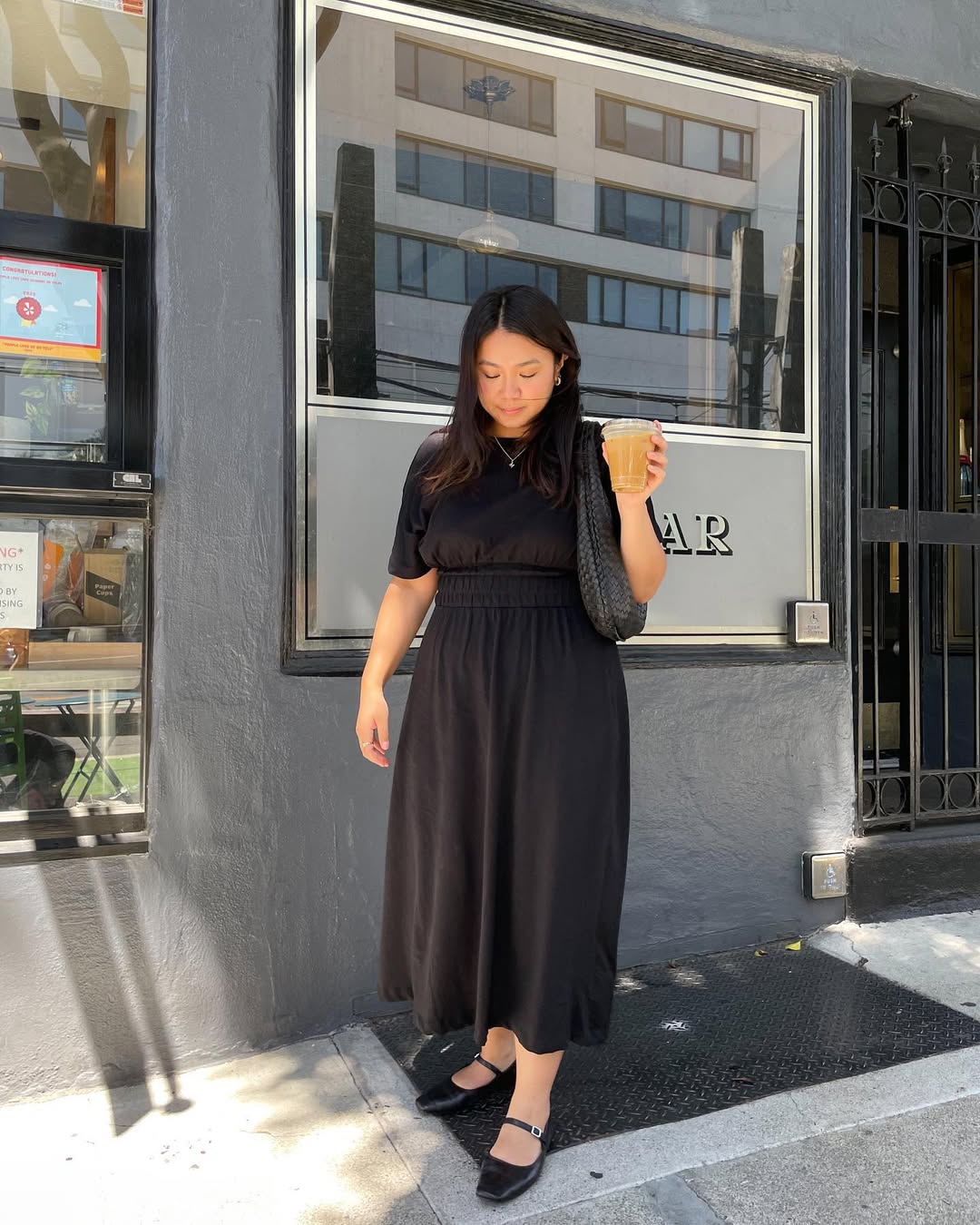 @marina_torres wears a black short-sleeve dress with Mary-Jane flats