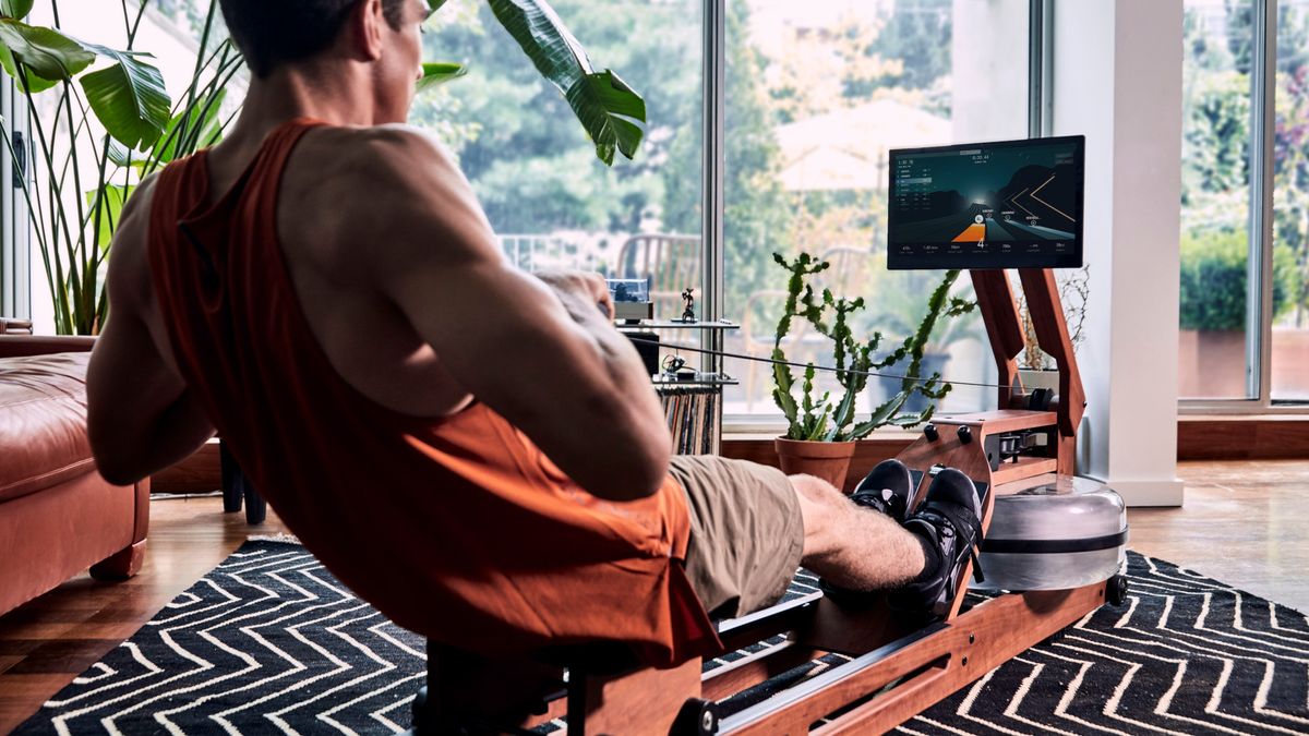 Man using Ergatta rowing machine at home