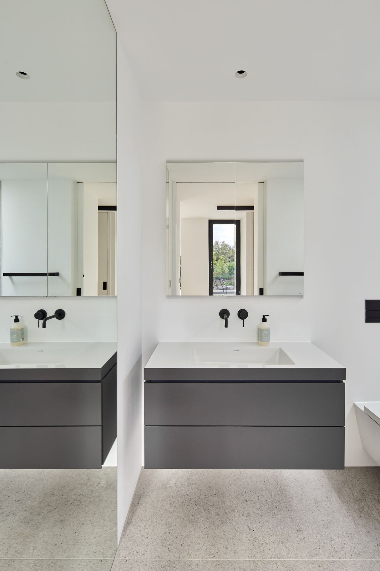 A white minimalist bathroom with a wall hung vanity unit and mirror