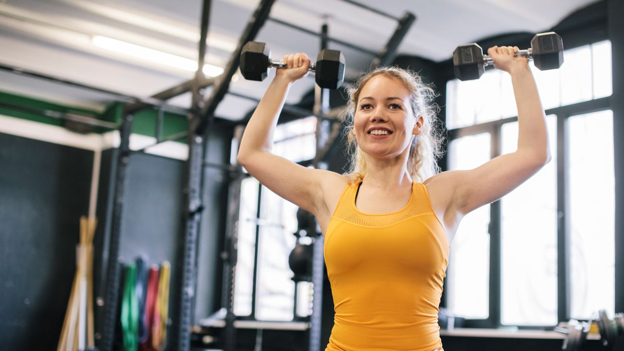 Woman doing dumbbell overhead press