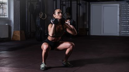 Woman doing dumbbell squat
