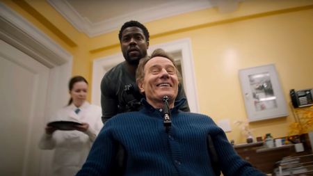 Kevin Hart riding around on the back of Bryan Cranston's wheelchair in The Upside.