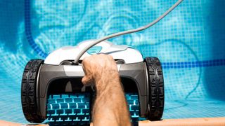 A man holding a robot pool cleaner