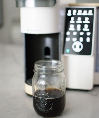 Heather Bien making hot coffee in a glass container using the Bruvi coffee maker