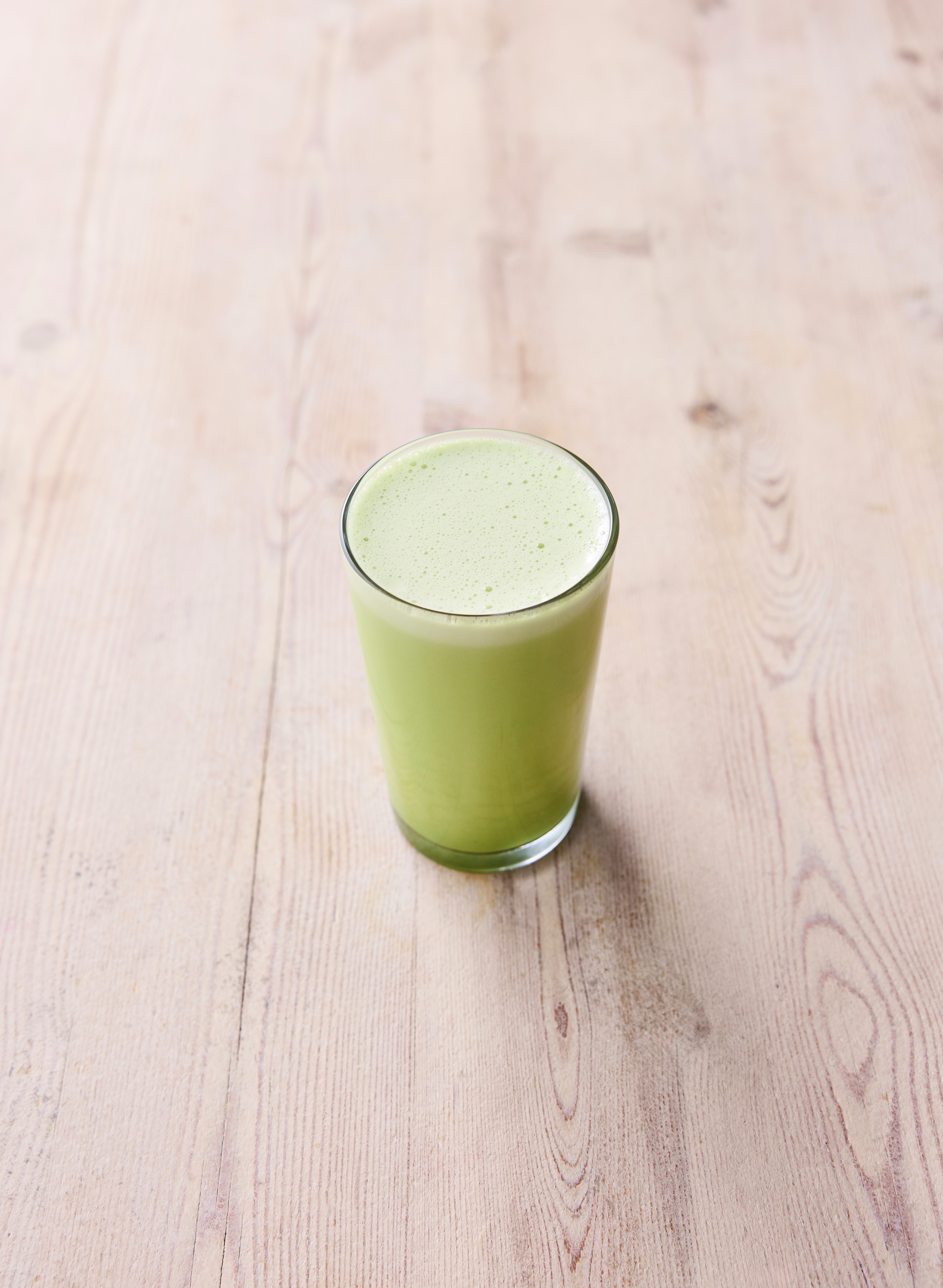 A matcha smoothie on a wooden table