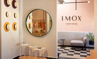 Imox boutique with round mirror, Panama hats on wall and black and white floor tiles