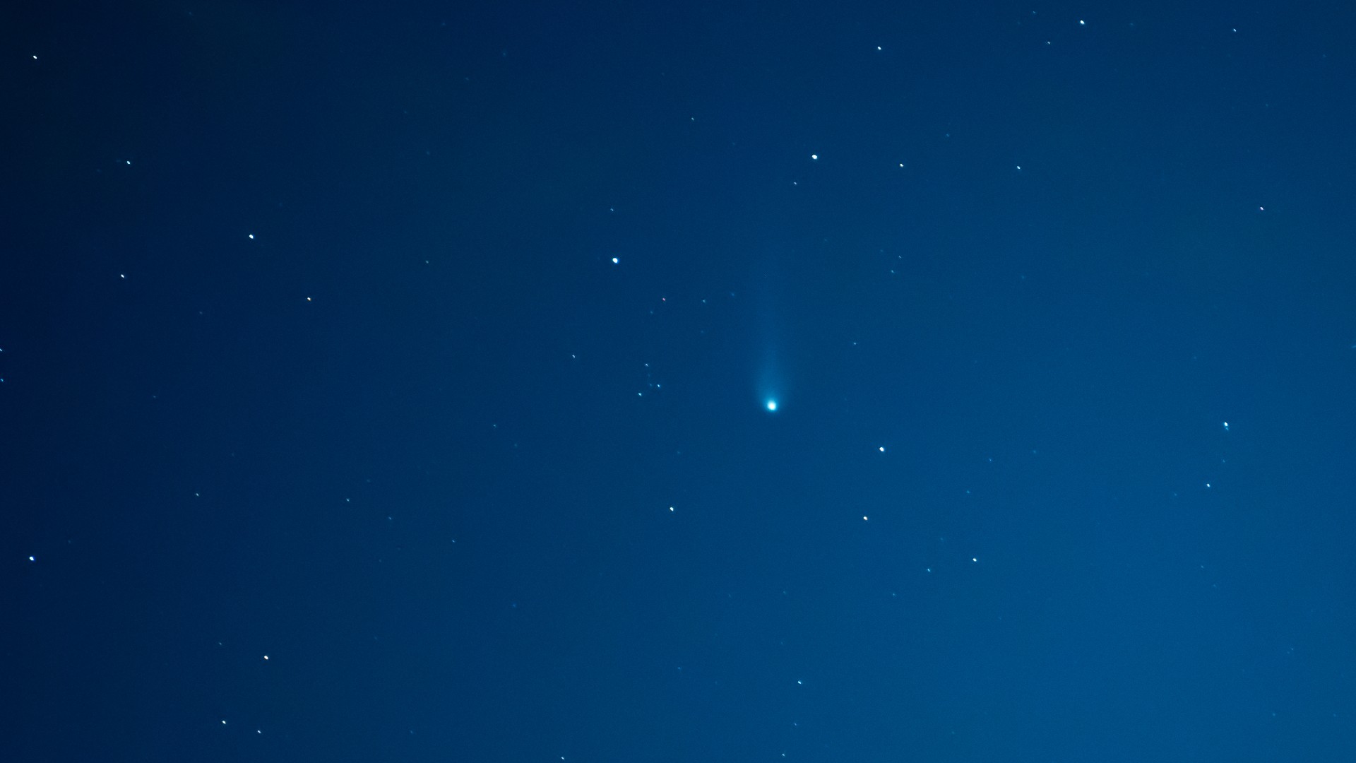 a fuzzy green comet in the night sky