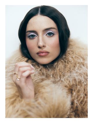 Madeline Argy looks to camera wearing a furry coat by Givenchy
