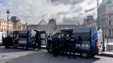 Police near the entrance to the Louvre in Paris following a massive heist at the museum