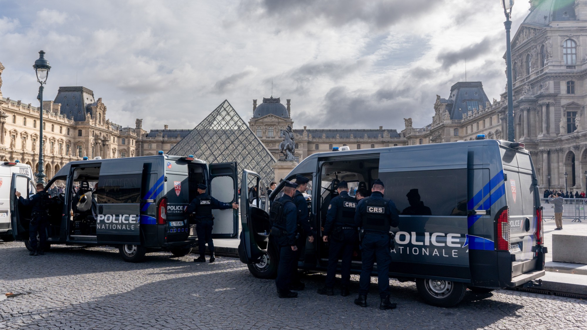 Police near the entrance to the Louvre in Paris following a massive heist at the museum