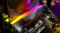 A close-up photo of a set of Corsair DDR5 DIMMs installed in a motherboard, lit by their own RGB lights