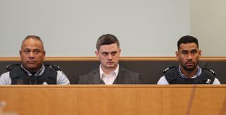 Jesse Kempson sat between two police officers in a court room