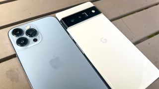 pixel 6 pro vs iphone 13 pro max: both phones laying face down to show camera modules