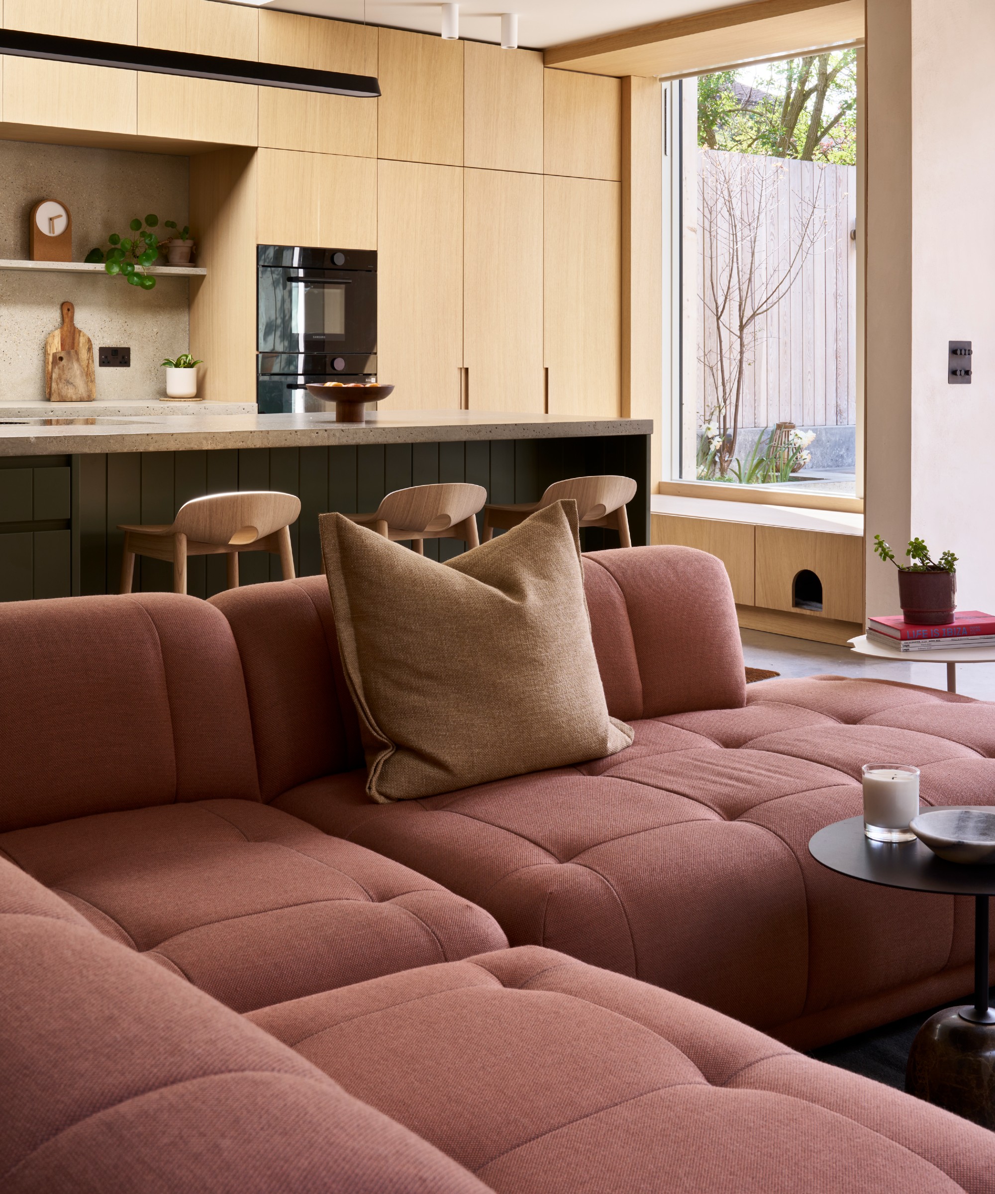 An open-plan living room with a modern modular sofa in earthy red