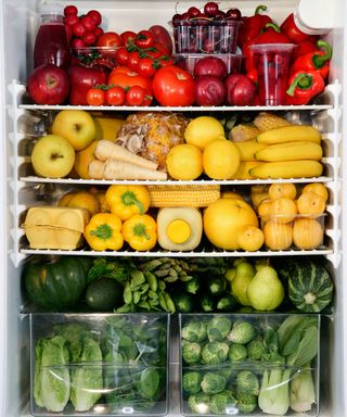 a beautifully colorful fridge with fruit and vegetables organized by color