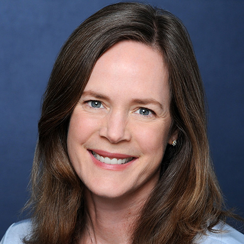 A woman with long straight hair smiles at the camera.
