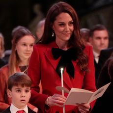 Kate Middleton wears a bright red dress with an oversized black bow and holds a candle to attend the annual Christmas carol concert in London with son Prince Louis, and Prince William meets with Donald Trump at the reopening of Notre Dame in Paris