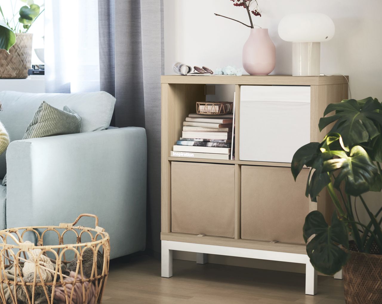 A living room with a wooden effect IKEA KALLAX unit on a white legged underframe