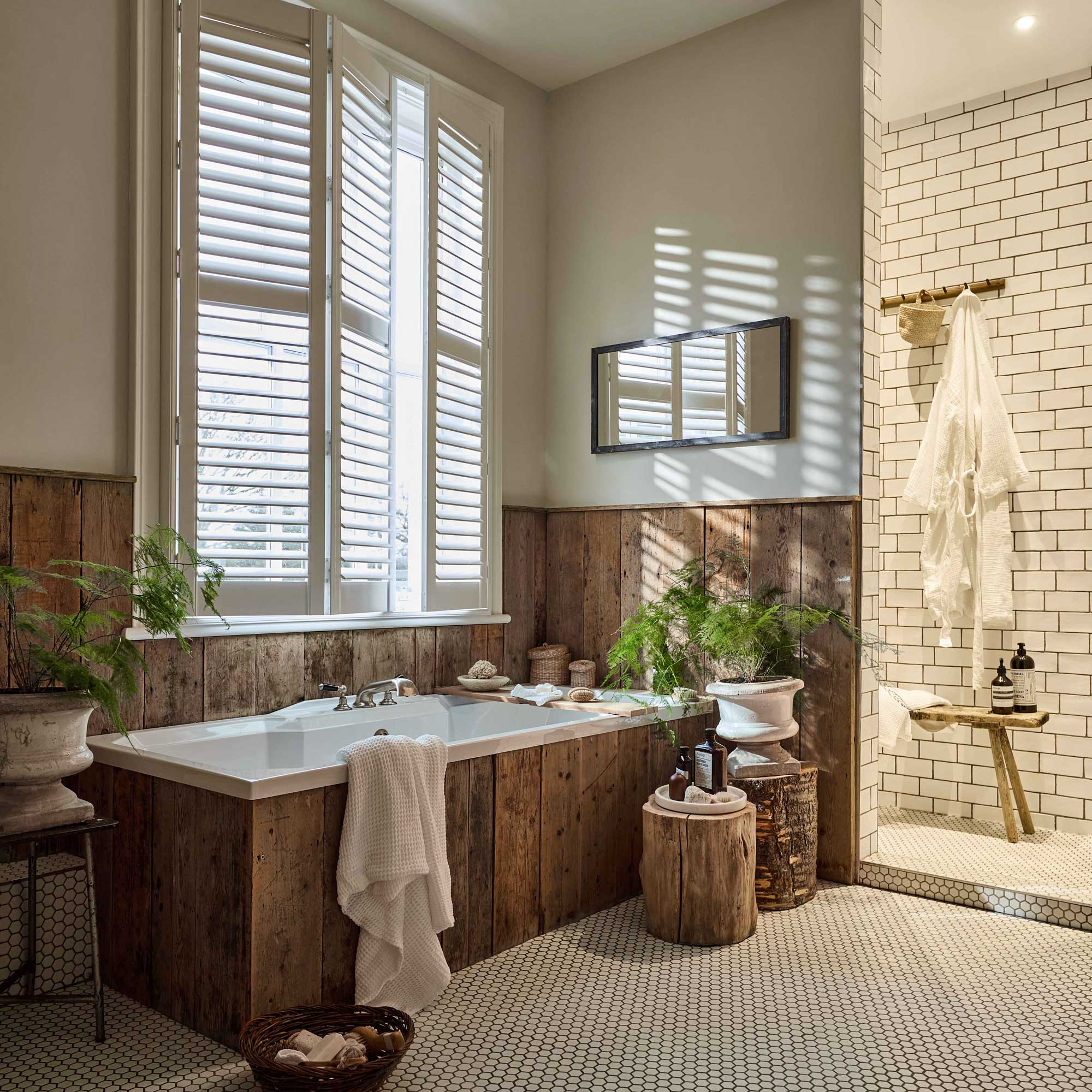 bathroom with wooden clad bath and wooden panelling and small hexagonal floor tiles