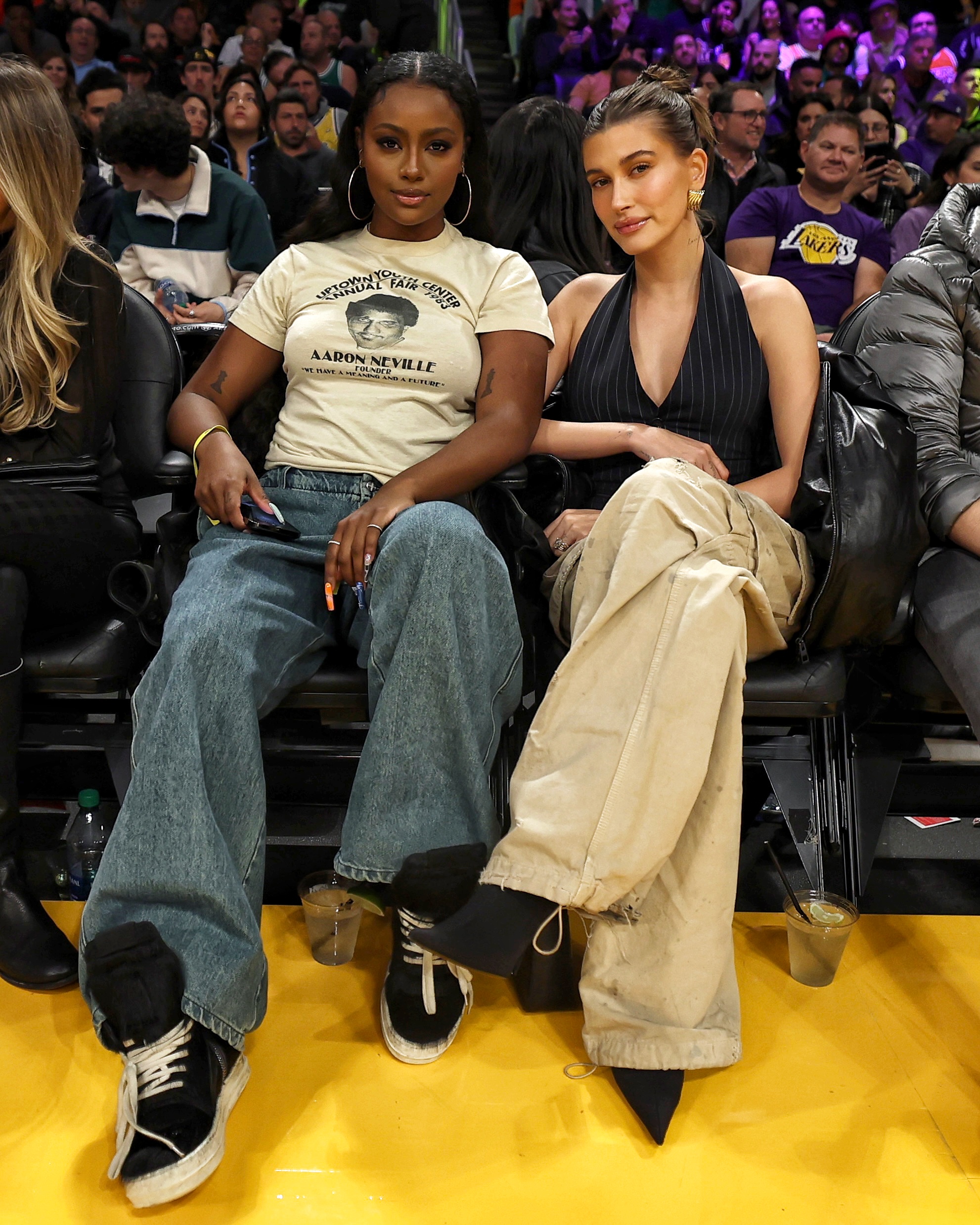 Justine Skye and Hailey Bieber sitting courtside at an NBA game.