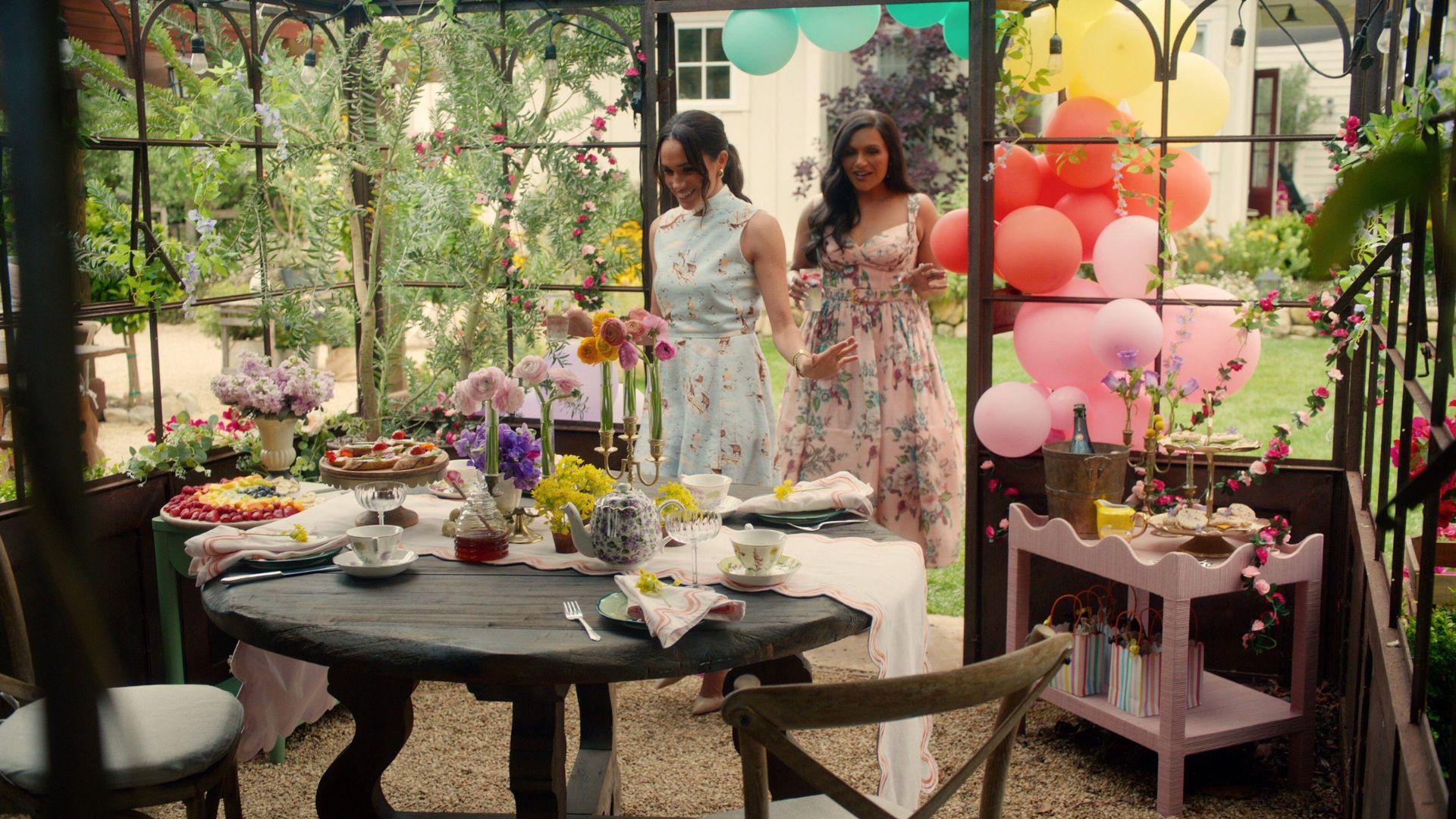 Meghan Sussex and Mindy Kaling enter a sunroom set up for a children's party