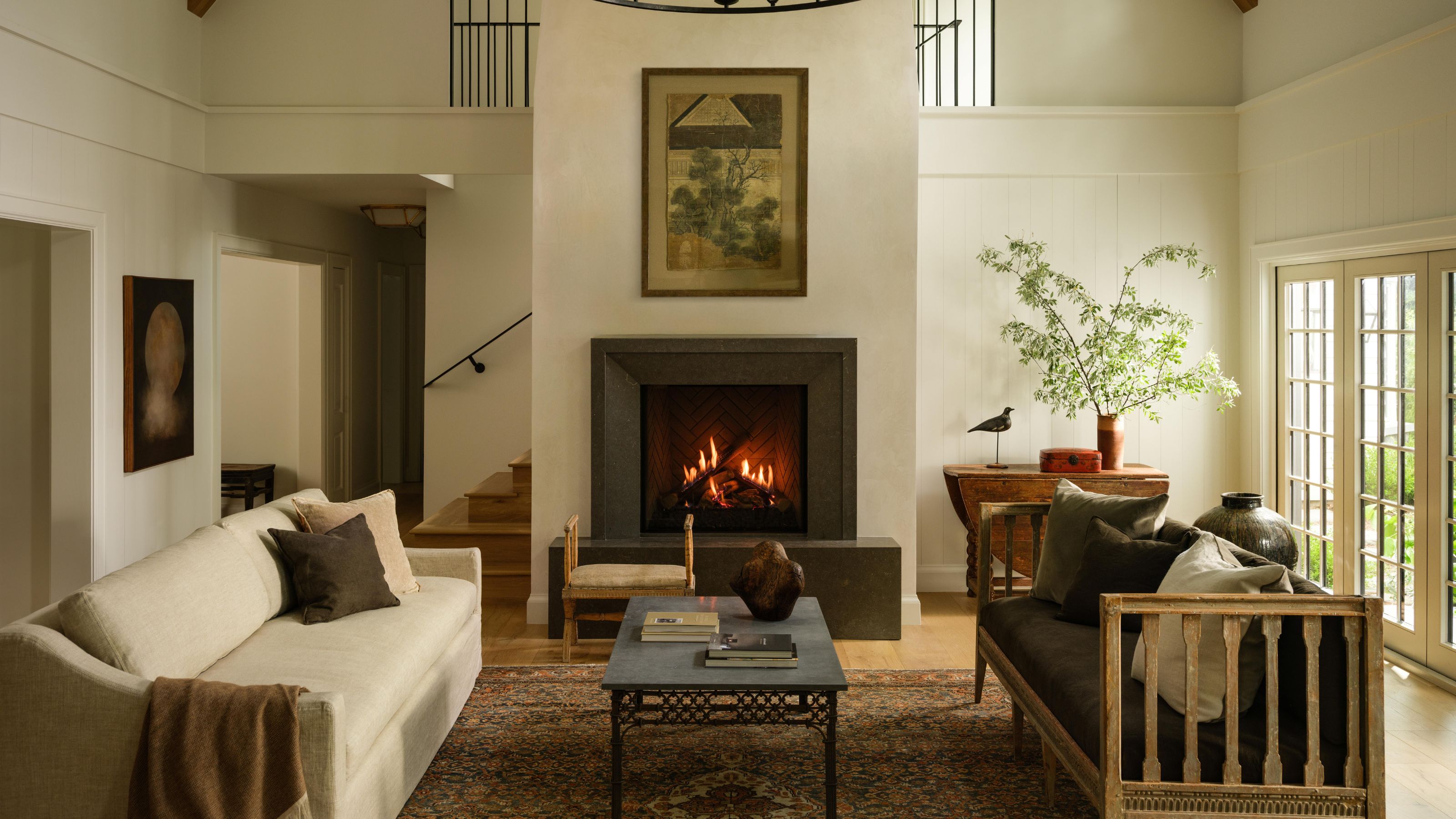 the great room in a cherry hills cottage reimagined with a vaulted ceiling, restored fireplace, vintage rug and furniture