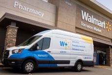 A Walmart Plus van outside a Walmart store.