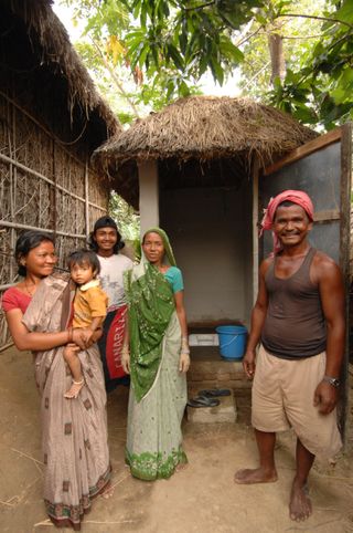A family stands outside their award winning toilet built with WaterAid's assistance in Beli, Terai region, Nepal