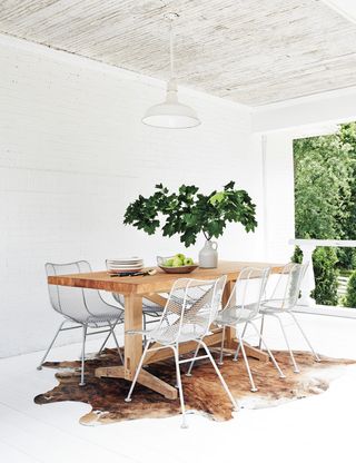 White dining room with rustic panelled ceiling