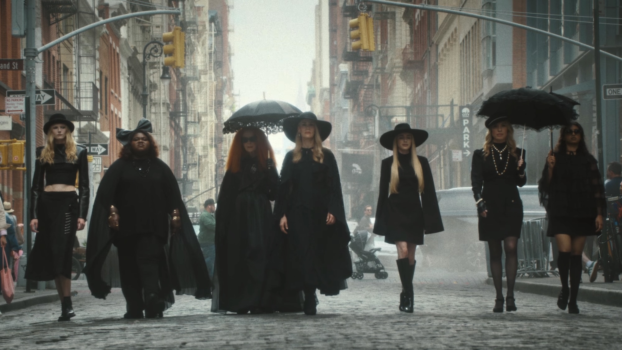 Lineup of Coven witches walking down a New Orleans street In American Horror Story 13