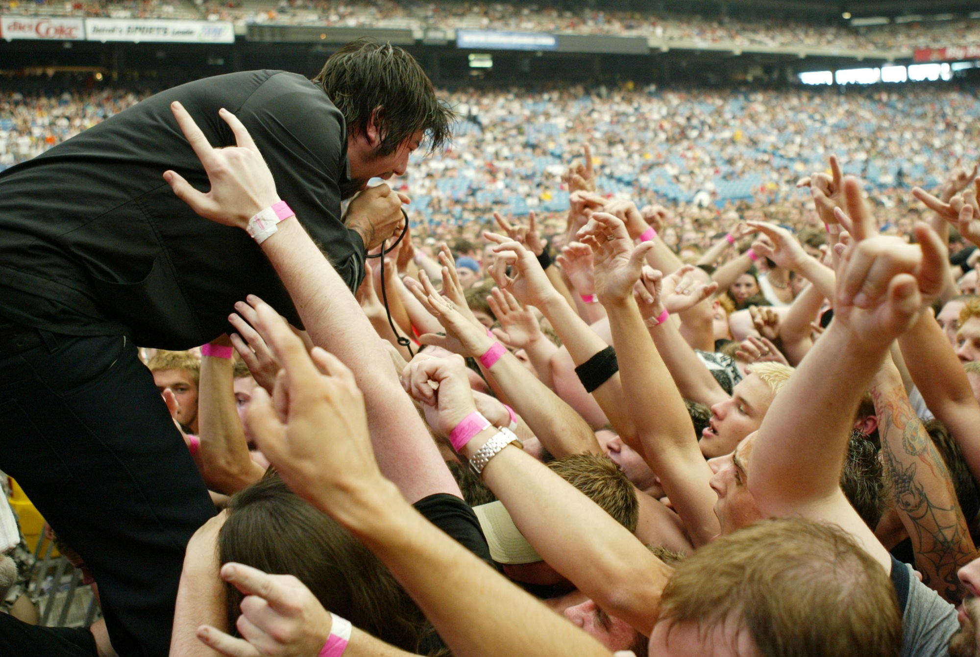 Chino Moreno of Deftones screams into the mic while surrounded by fans at the Pontiac Silverdome in Detroit, Michigan in 2003