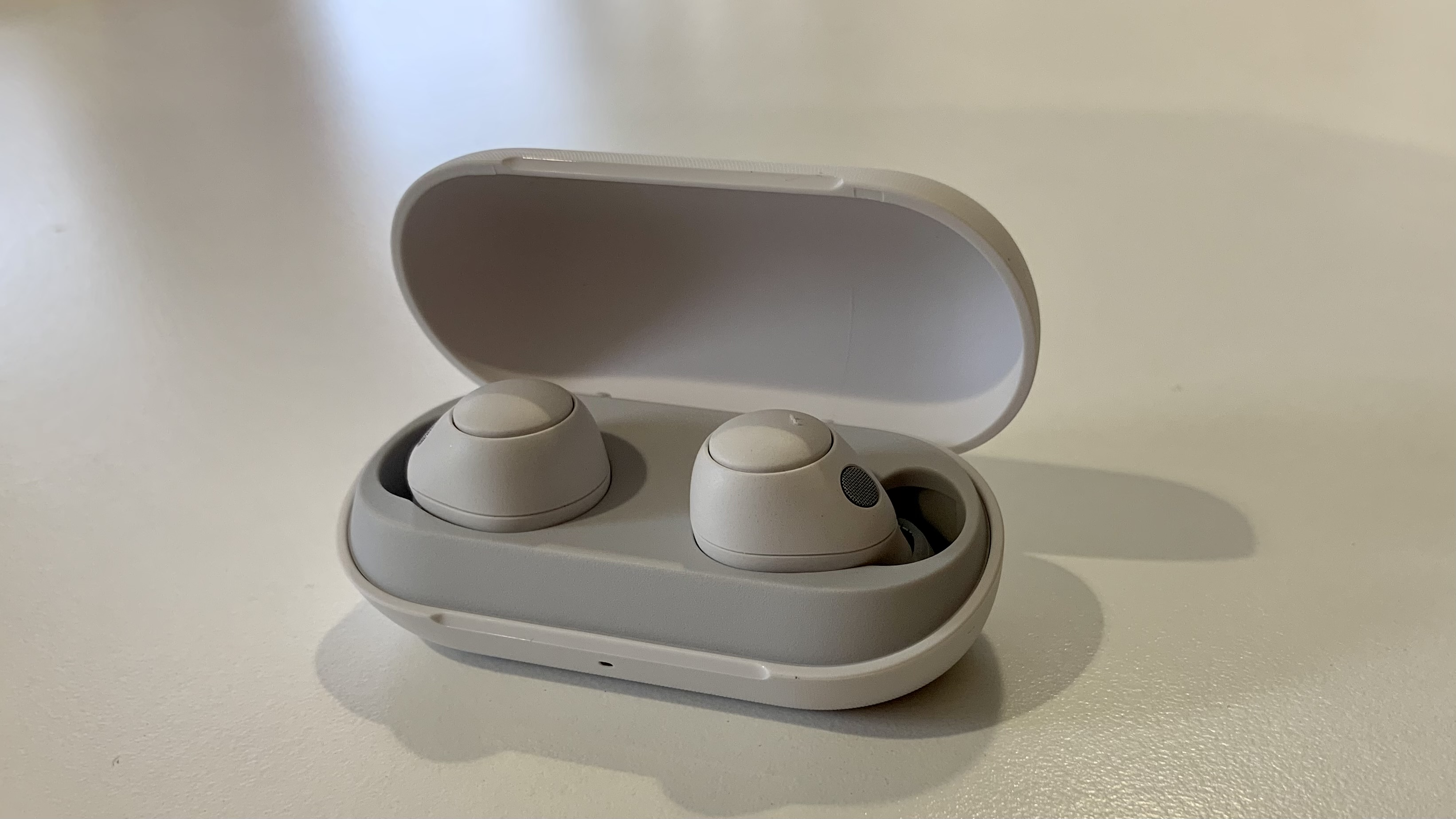 Sony WF-C700N earbuds in their case, on white background