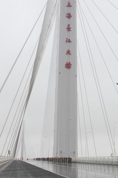 The peloton was dwarfed by the Changjiang Bridge.