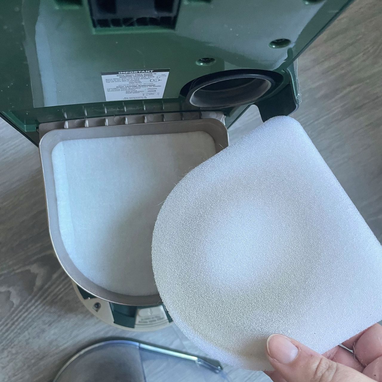 Hand holding a dirty filter of the Shark PowerDetect Transformer vacuum cleaner