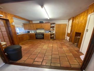 Becky Lane's old pine kitchen, with pine cupboards and a pine wall, and an orange tile floor