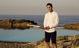 The HILL Tailored Henley Shirt, ROSS Double Jersey Sweatshorts. A man standing in front of the sea wearing casual clothing.