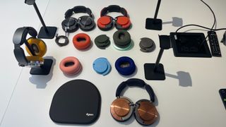 Dyson OnTrac headphones with various finishes and earcup colours laid out on desk